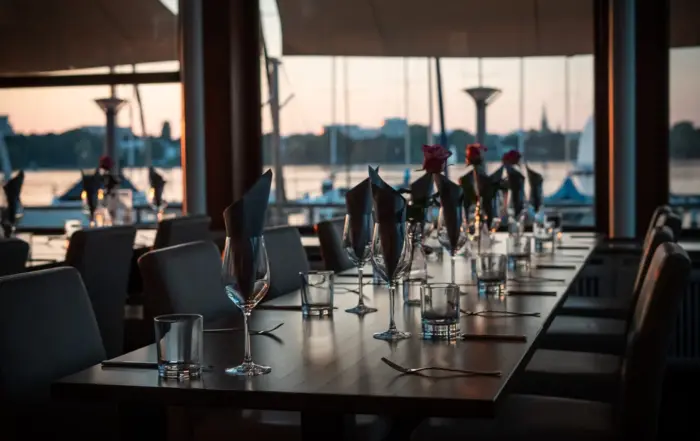 Blick auf eine gedeckte Tafel des Restaurants bei dem man den Blick auf die Alster sieht